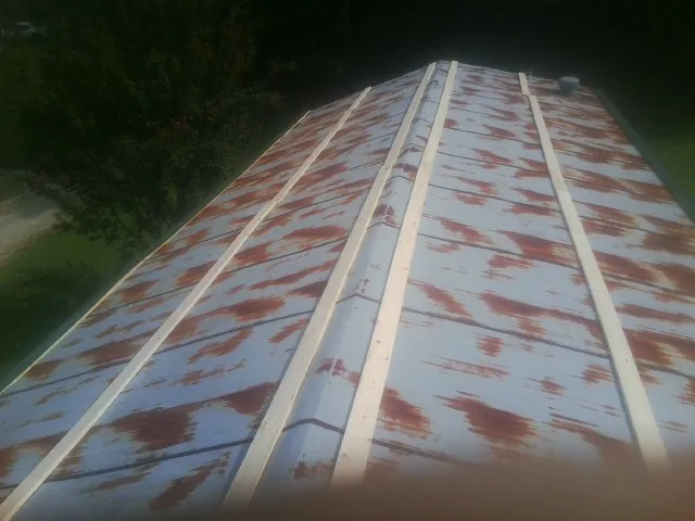 Rusted metal roof panels with new wood purlins before replacement — Storm Damage Roof Repair in Harborcreek by Roofing Brothers