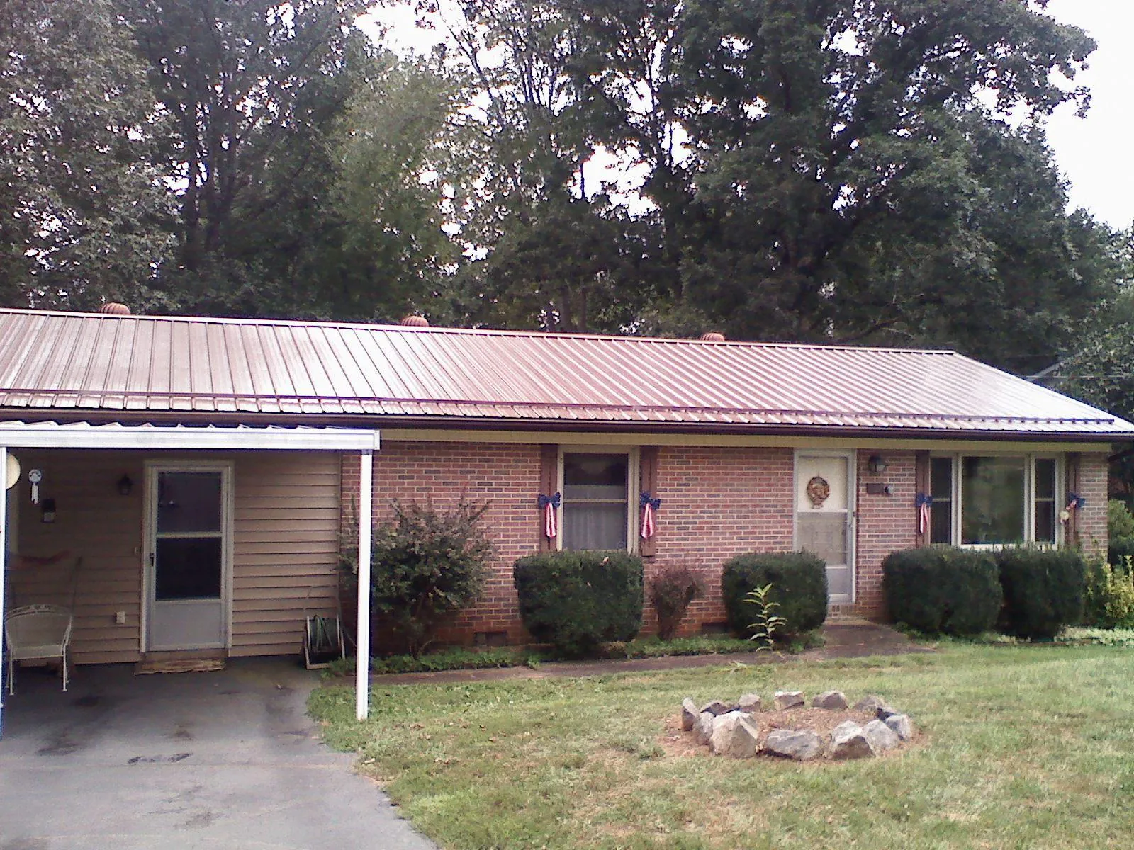 Bronze metal roof and carport on a brick ranch home — Roof Repair work by our crew in Harborcreek